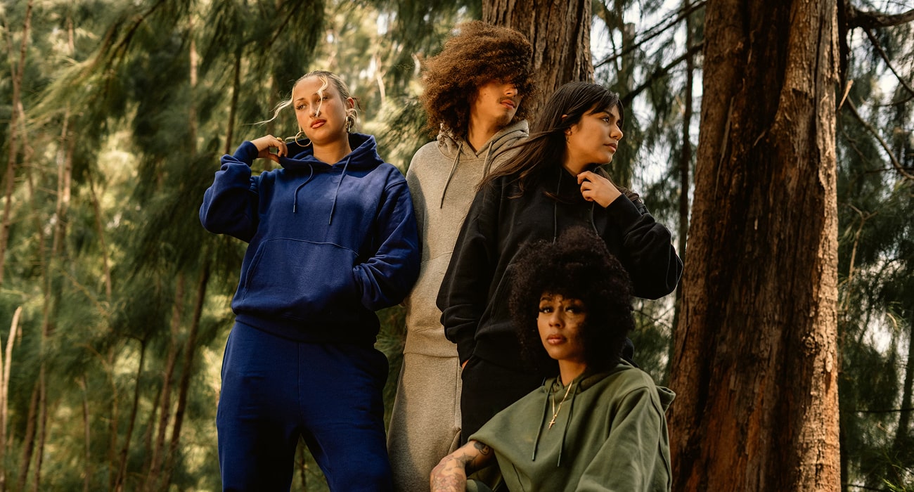 four models wearing solid pullover hoodies: navy relaxed, heather grey slim, black oversized, olive cropped—front group view